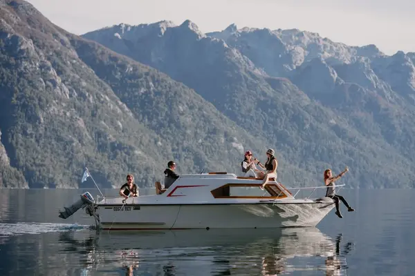 Embarcación de Nahuel Huapi a Bordo navegando el lago con la cordillera de fondo